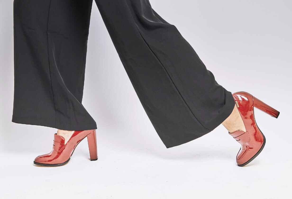 червени лачени дамски високи обувки и широк черен панталон