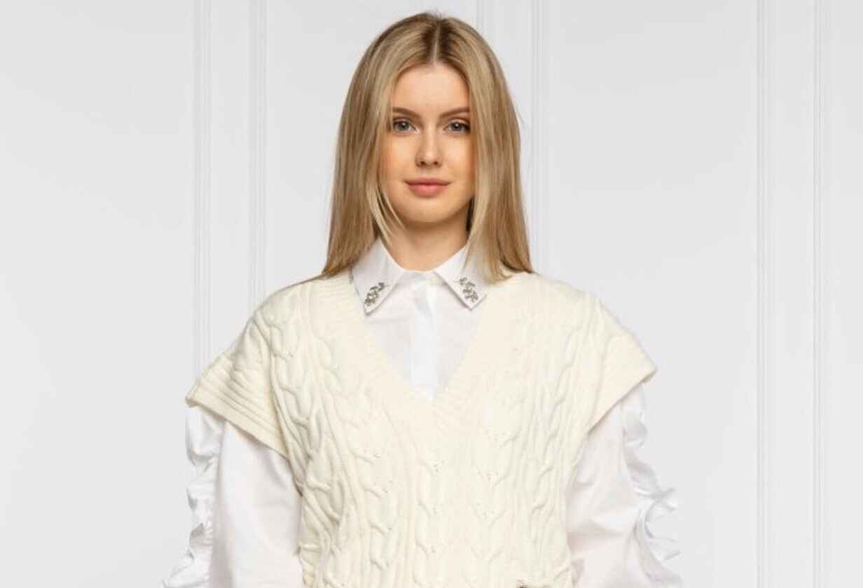 руса жена с бяла риза и бял пуловер без ръкави