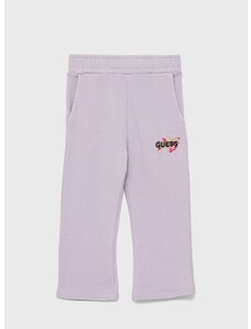 Детски памучен спортен панталон Guess в лилаво с апликация