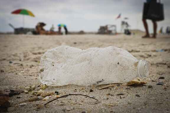 смачкана пластмасова бутилка на плажа
