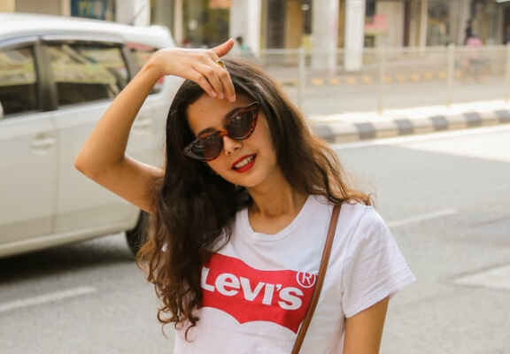 жена с очила котешко око и бяла тениска с лого на Levi's