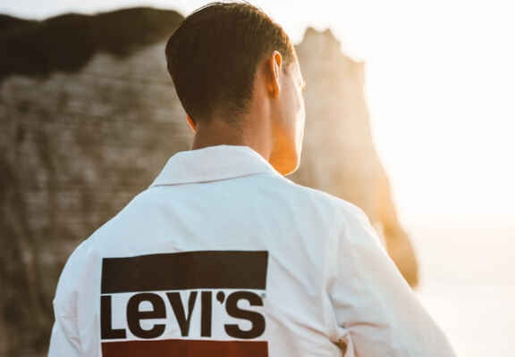 мъж с бяла риза с лого на Levi's на гърба