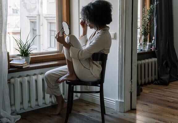 жена се гримира в огледало по пижама