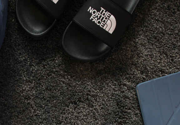 черни чехли на The North Face на килим